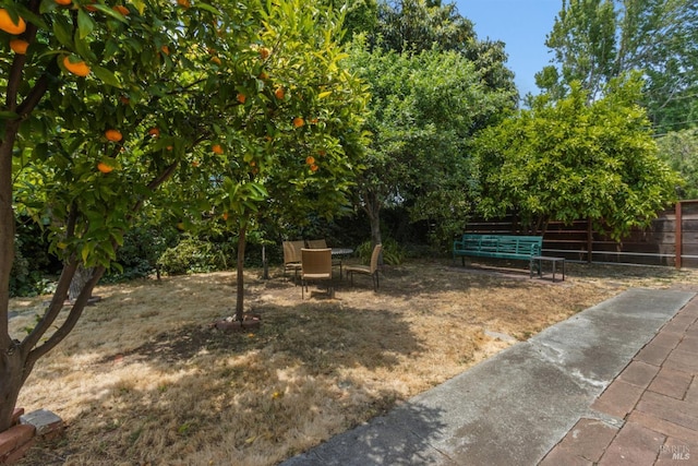 view of yard with outdoor dining space and fence