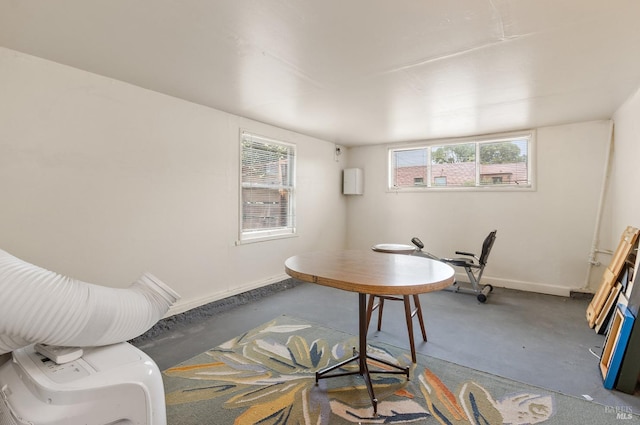home office featuring concrete floors and baseboards