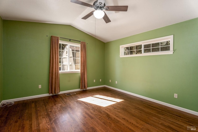 spare room with a ceiling fan, visible vents, vaulted ceiling, wood finished floors, and baseboards