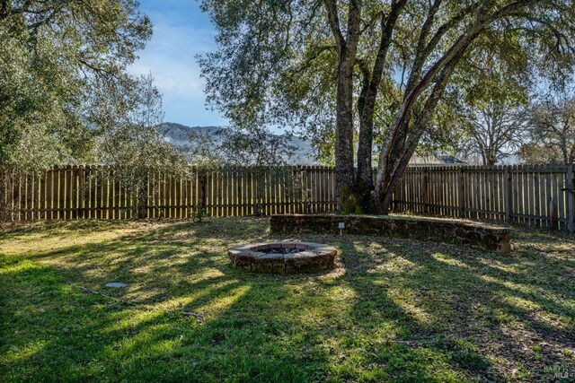 view of yard featuring an outdoor fire pit and a fenced backyard
