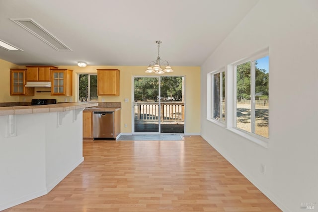 kitchen featuring glass insert cabinets, light wood finished floors, dishwasher, and tile counters