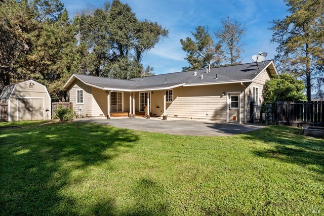 back of house featuring a patio, an outdoor structure, fence, and a storage unit