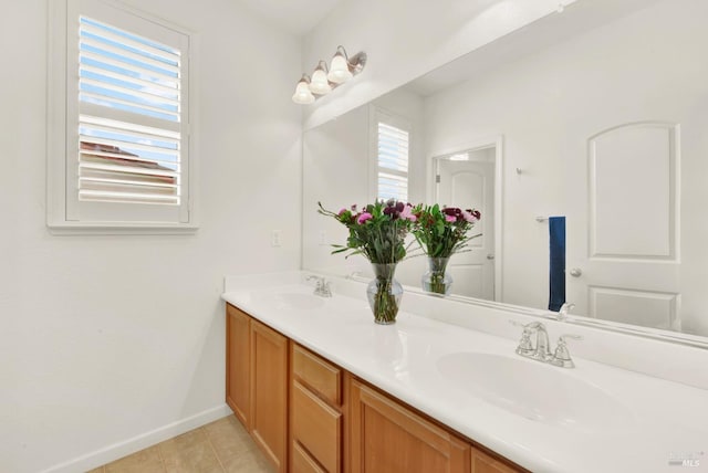 full bathroom with double vanity, baseboards, a sink, and tile patterned flooring