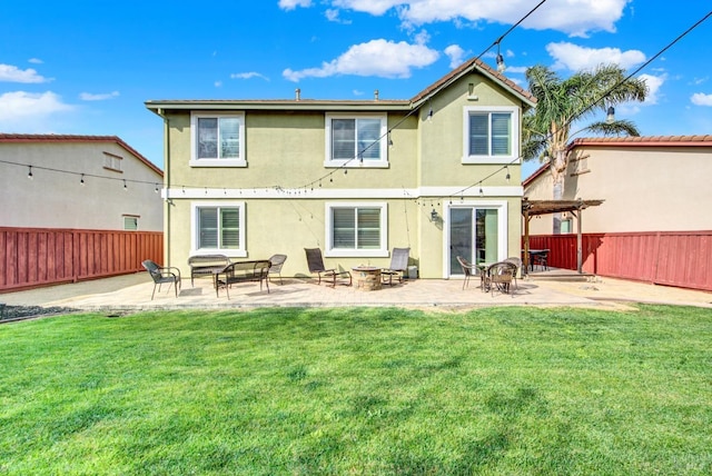 back of house featuring a fenced backyard, stucco siding, a patio area, and a yard