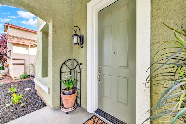 view of exterior entry featuring stucco siding