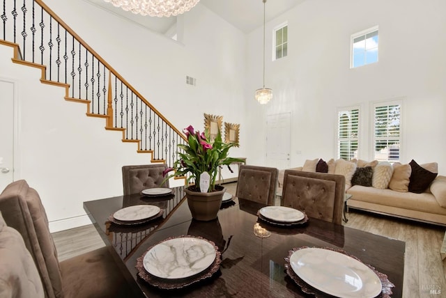 dining space with baseboards, visible vents, wood finished floors, and stairway