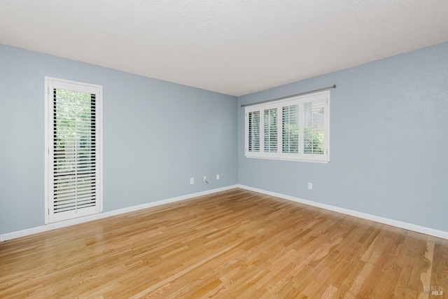 unfurnished room with light wood-style flooring and baseboards