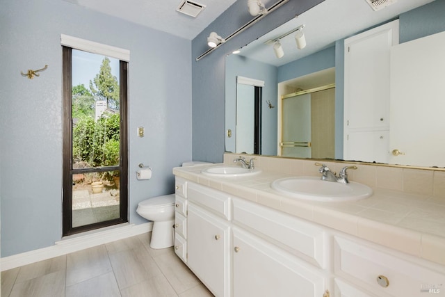 bathroom featuring double vanity, visible vents, a sink, and a stall shower