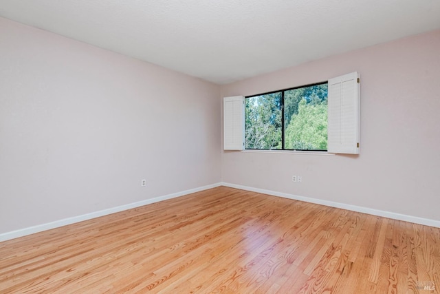 empty room featuring wood finished floors and baseboards