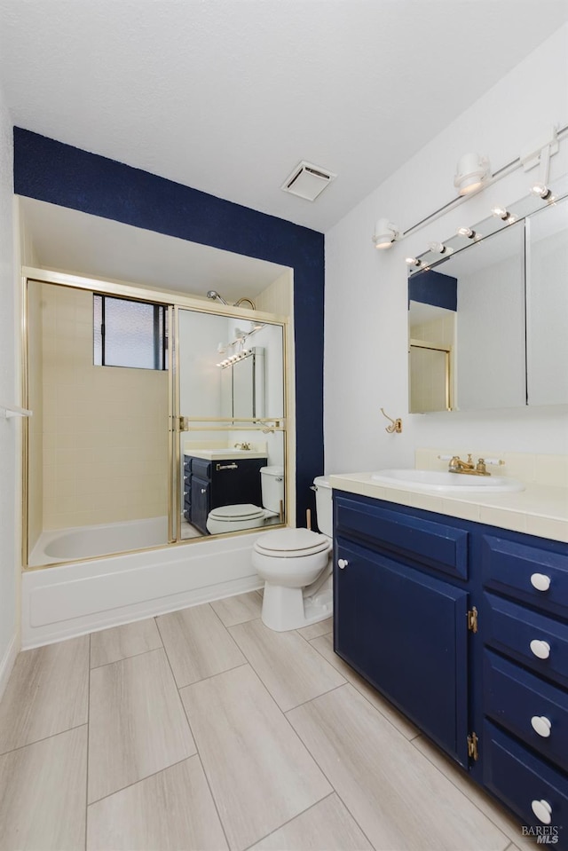 bathroom with toilet, vanity, shower / tub combination, and visible vents