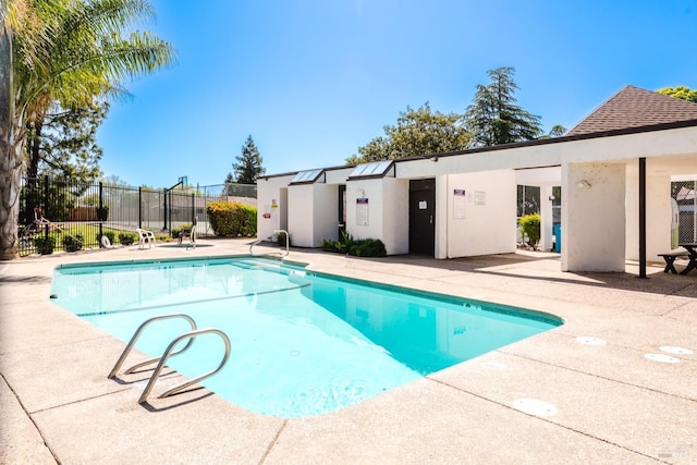 pool with a patio area and fence