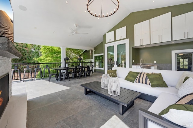 4071 Bones Rd, Sebastopol, CA 95472 - living area with an outdoor stone fireplace, french doors, a chandelier, high vaulted ceiling, and ceiling fan