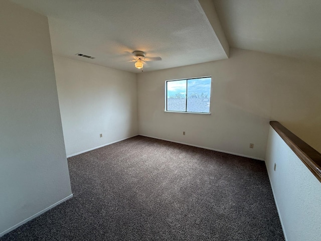 empty room featuring ceiling fan, visible vents, baseboards, and dark colored carpet