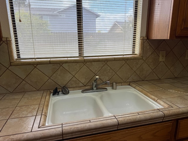 interior details featuring tile counters, a sink, and backsplash