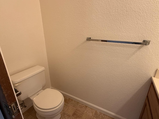 bathroom featuring vanity, baseboards, and toilet
