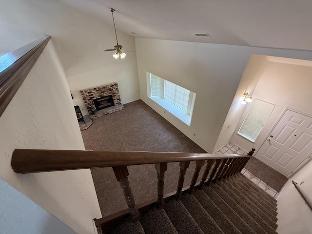 stairs featuring visible vents, carpet flooring, a ceiling fan, and lofted ceiling