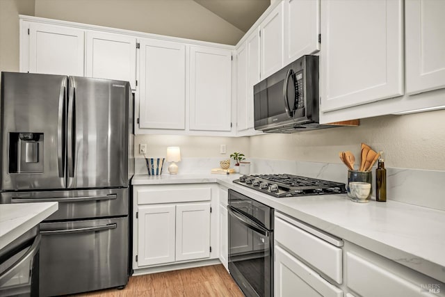 kitchen featuring white cabinetry, black appliances, and light countertops