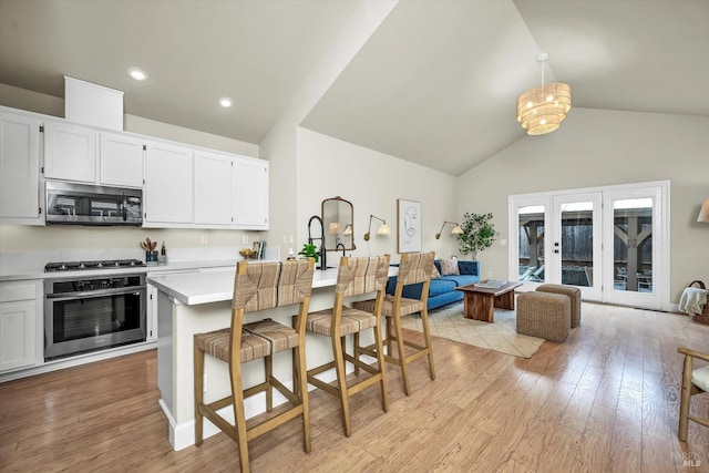 kitchen featuring light wood-type flooring, light countertops, appliances with stainless steel finishes, and white cabinets