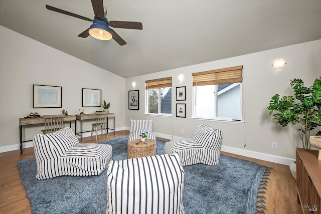 living room featuring baseboards, lofted ceiling, wood finished floors, and a ceiling fan