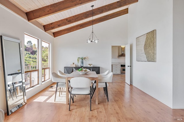 dining room featuring beamed ceiling, a notable chandelier, light wood-style flooring, and wood ceiling
