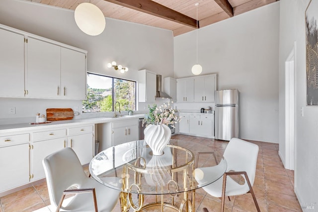 dining room with wood ceiling, light tile patterned flooring, a high ceiling, and beamed ceiling