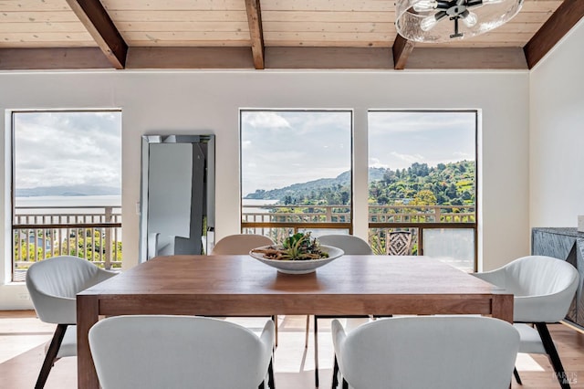 dining area with wood ceiling, beamed ceiling, a mountain view, and wood finished floors