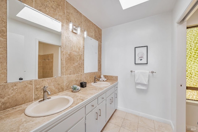 bathroom with double vanity, tasteful backsplash, a skylight, and a sink
