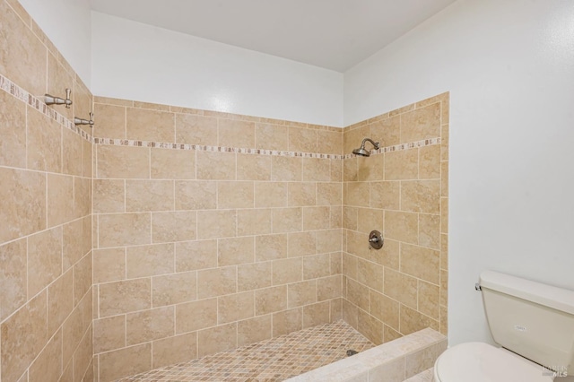 full bath featuring toilet and a tile shower
