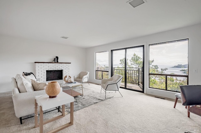 living area with light colored carpet, visible vents, and a brick fireplace