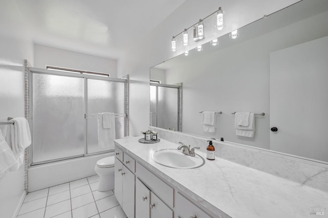 bathroom featuring enclosed tub / shower combo, tile patterned floors, toilet, and vanity