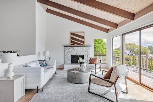 living area featuring wooden ceiling, high vaulted ceiling, beamed ceiling, a fireplace, and wood finished floors