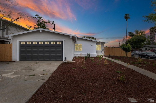 single story home featuring fence, stucco siding, driveway, and an attached garage