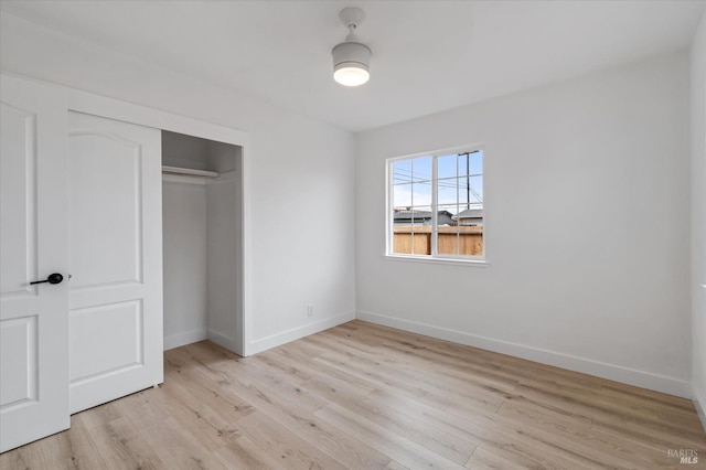 unfurnished bedroom featuring baseboards, a closet, and light wood finished floors