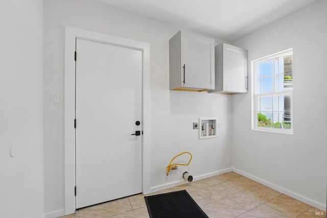 laundry area featuring washer hookup, light tile patterned floors, baseboards, cabinet space, and gas dryer hookup