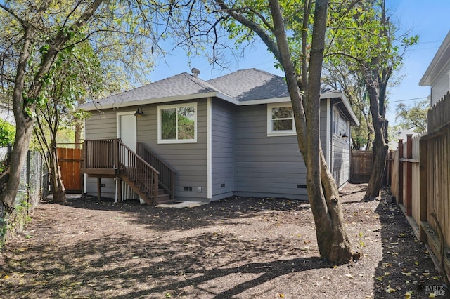 rear view of property with a fenced backyard, crawl space, and roof with shingles
