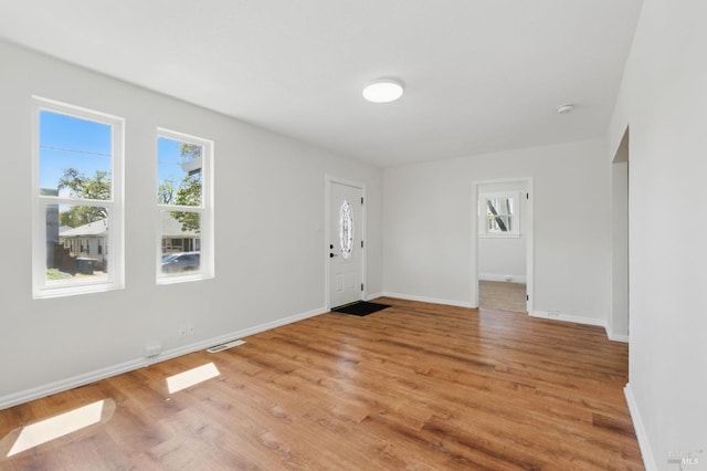 entryway with baseboards, visible vents, and light wood finished floors
