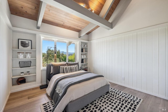 bedroom featuring lofted ceiling with beams, wooden ceiling, baseboards, and light wood-type flooring