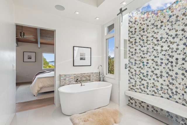 bathroom featuring tile walls, beamed ceiling, a freestanding bath, ensuite bath, and tile patterned flooring