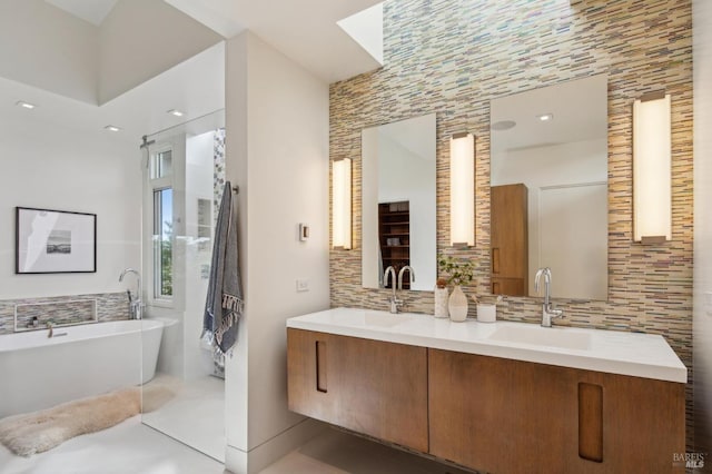 full bathroom featuring a soaking tub, double vanity, a sink, and decorative backsplash