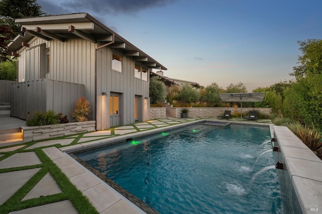 pool at dusk with a patio, a fenced in pool, and a fenced backyard
