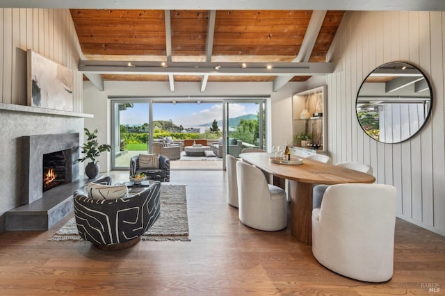 living area with wood ceiling, vaulted ceiling with beams, wood finished floors, wood walls, and a high end fireplace