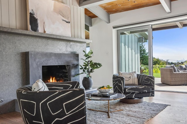 living room with wooden ceiling, wood finished floors, a premium fireplace, and beam ceiling
