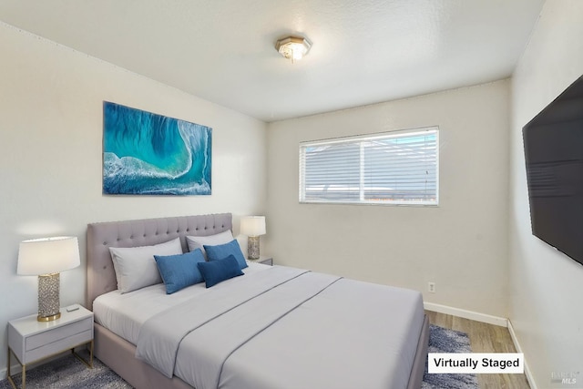 bedroom featuring baseboards and wood finished floors