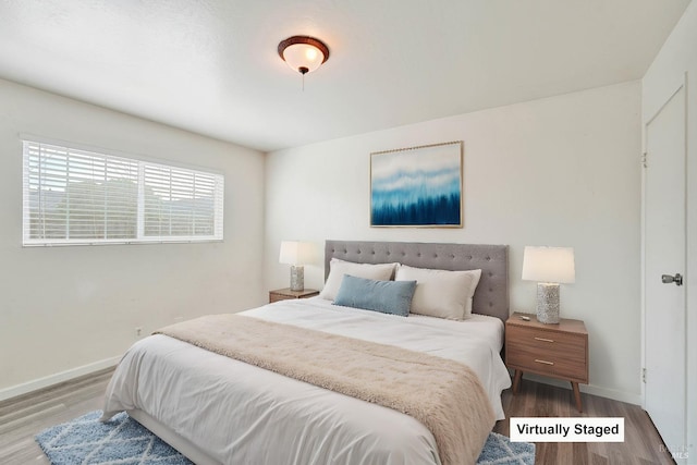 bedroom with baseboards and wood finished floors