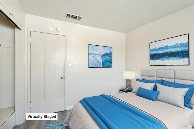 bedroom featuring wood finished floors and visible vents