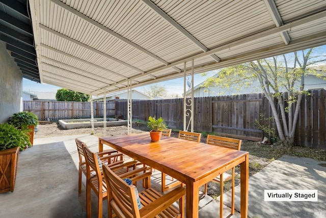 view of patio / terrace with a fenced backyard, outdoor dining space, and a garden