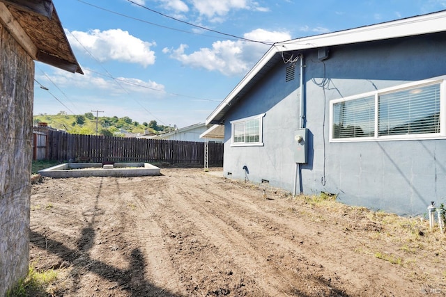 view of home's exterior featuring stucco siding and fence