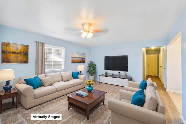 living room with a ceiling fan and light wood-style flooring