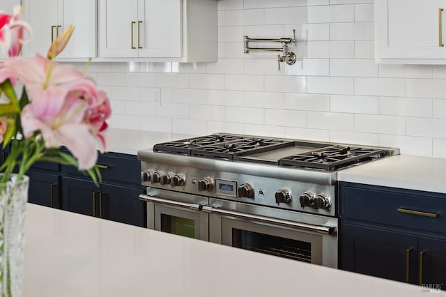 kitchen with light countertops, backsplash, and double oven range