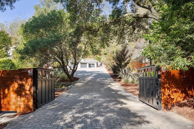 view of road featuring a gate, a gated entry, and decorative driveway